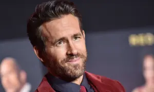 Ryan Reynolds, gwiazda wielu komediowych **filmów**, w bordowym garniturze.