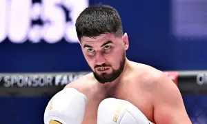 Bokser Hubert Dajczman w białych rękawicach, z widocznymi złotymi nakładkami na zębach.