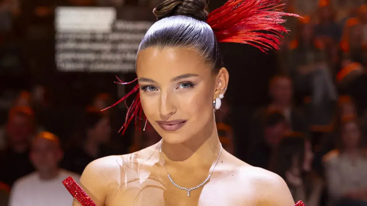 Julia Wieniawa na scenie, zjawiskowa w czerwieni. Jej wzrost i stylizacja przyciągają uwagę.