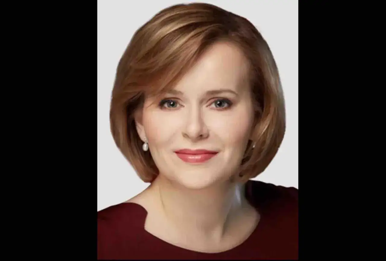 Portret Anny Krupki. Uśmiechnięta kobieta o krótkich, brązowych włosach i perłowych kolczykach. Jej życie prywatne budzi zainteresowanie.