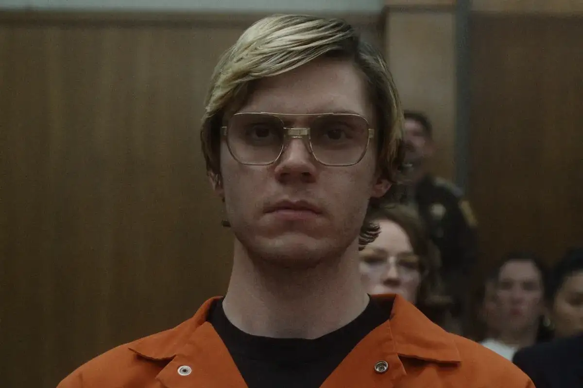 Jeffrey Dahmer w pomarańczowym kombinezonie, w okularach, w sali sądowej. dahmer – potwór: historia jeffreya dahmera.
