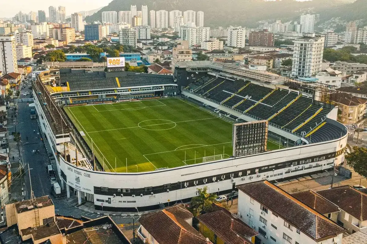 Stadion Urbano Caldeira, gdzie grał Neymar, z zieloną murawą i trybunami otoczony miejską zabudową.