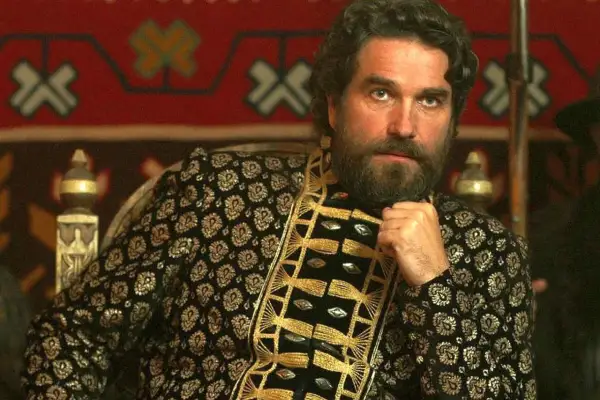 Marcin Dorociński w bogato zdobionej, złotej szacie, jak z filmów i seriali. W tle orientalny wzór.