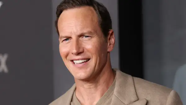 Uśmiechnięty Patrick Wilson, znany z wielu filmów, w beżowej marynarce.