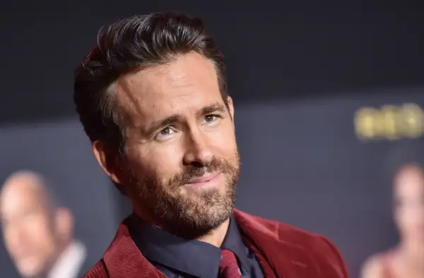Ryan Reynolds, gwiazda wielu komediowych **filmów**, w bordowym garniturze.