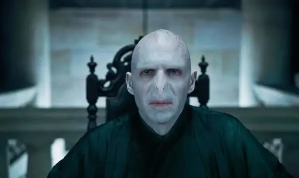 Ralph Fiennes jako Lord Voldemort w filmach o Harrym Potterze. Jego przerażająca twarz i mroczny strój budzą grozę.