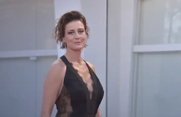 Maja Ostaszewska w czarnej, koronkowej sukni na czerwonym dywanie. Aktorka znana z wielu polskich filmów.