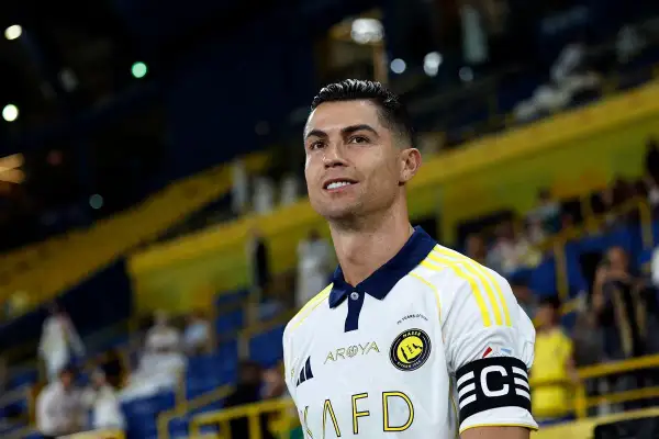 Cristiano Ronaldo w białej koszulce z żółtymi pasami, grający w jednej z obecnych drużyn.